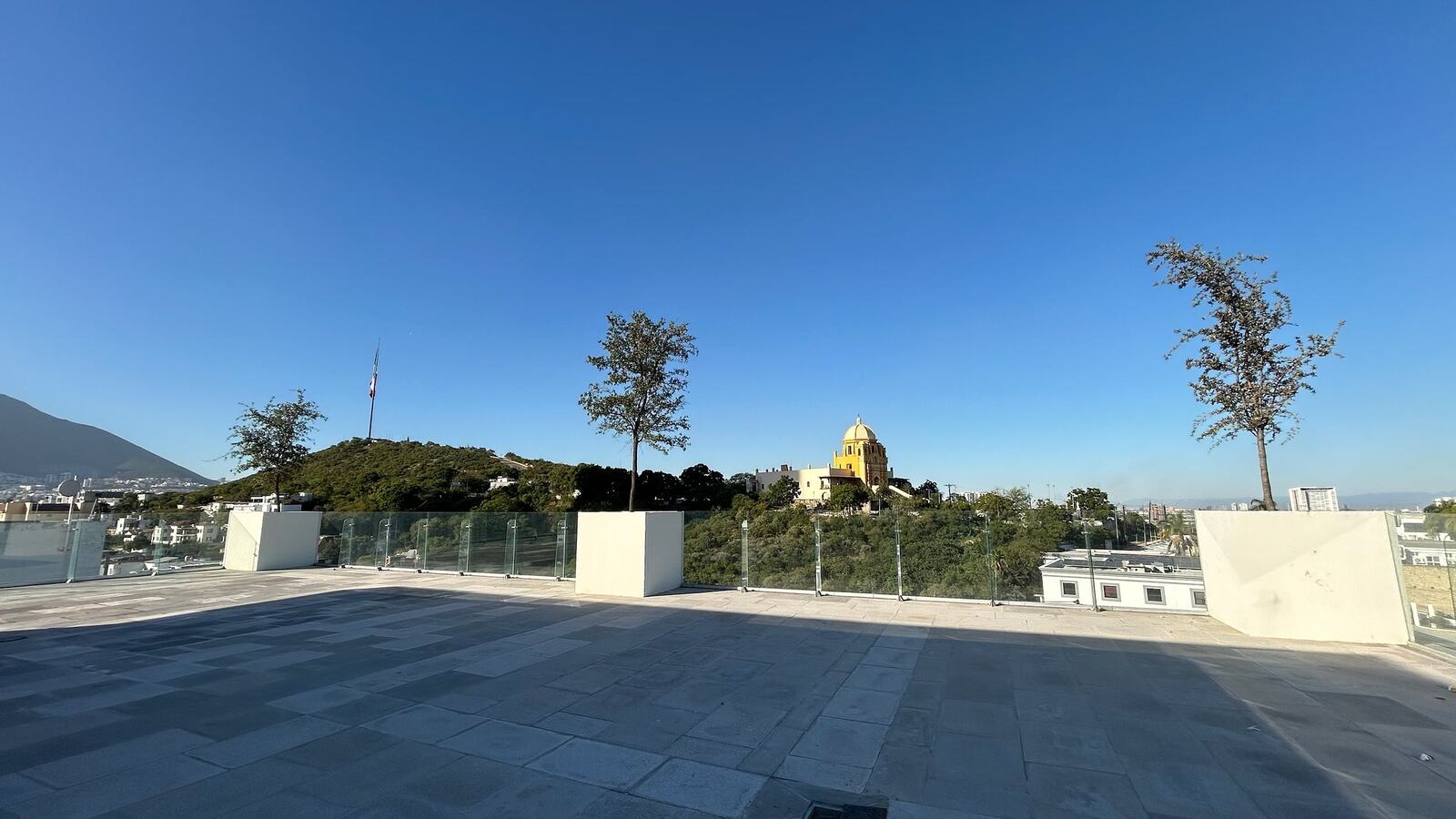 Terraza ALTUM con jardineras y el Obispado al fondo, a pleno sol